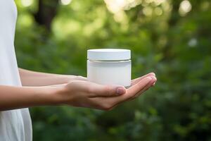 AI generated Woman hands holding blank white cosmetic jar mockup on nature background photo