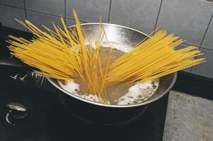 pasta es cocido en hirviendo agua en un cacerola. foto