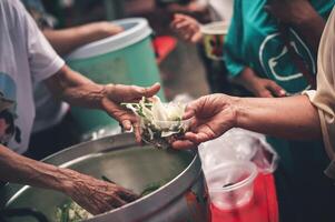 Hands of poor people asking for food from volunteers helping concept of food donation photo