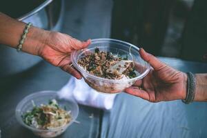 Hands of poor people asking for food from volunteers helping concept of food donation photo