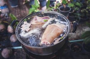 The pork leg pieces are boiled in a pot to make the dish. photo