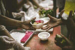 Hands of poor people asking for food from volunteers helping concept of food donation photo