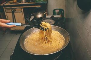 pasta es cocido en hirviendo agua en un cacerola. foto