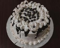 Delicious Birthday Cake with White Cream and Chocolate on wooden table top View - Sweet Dessert photo