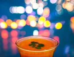 Orange Juice in Bar Glass in front of blurry blinking lights background photo