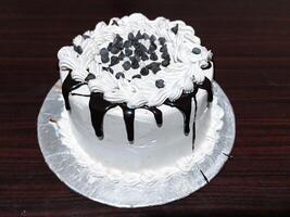 delicioso cumpleaños pastel con blanco crema y chocolate en de madera mesa parte superior ver - dulce postre foto