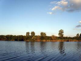 Autumn Colorful Trees ant the Blue River and Sky photo