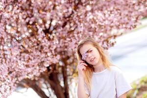 joven mujer viajero mirando Cereza flores o sakura flor floreciente foto