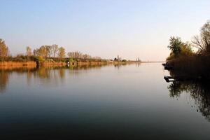 lago casa en otoño reflejando en tranquilo río foto