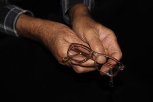 Glasses and senior man's hands photo