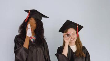 Young African American and caucasian women stand side by side and look at their education diplomas as if in a telescope video