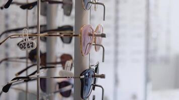 A wide range of different glasses in the store or ophthalmology clinic. Side rack view video