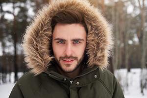 atractivo barbado hombre en pie al aire libre en invierno temporada bosque. foto