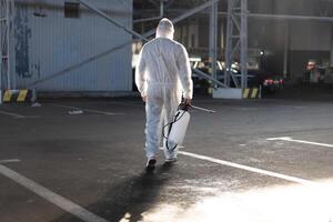 Man dressed white protective overalls spraying surface antibacterial sanitizer sprayer during quarantine photo