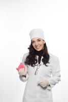 a woman in a white coat holding a pink device photo