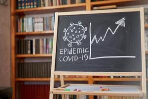 Outbreak Warning. written white chalk on blackboard in connection with epidemic of coronavirus worldwide. photo