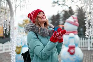 Beautiful lovely middle-aged girl with curly hair warm winter jackets stands ice rink background Town Square. photo