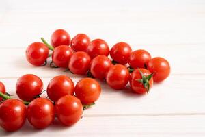 Cherry tomatoes on the white wooden table photo