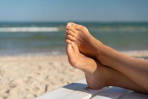 Female foot with hallux valgus close up on the beach photo