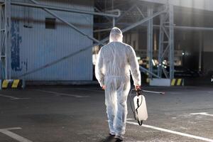 hombre vestido blanco protector mono pulverización superficie antibacteriano desinfectante rociador durante cuarentena foto