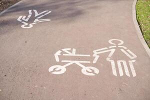 firmar mamá con un paseante dibujado por blanco pintar en el la carretera en el parque. foto