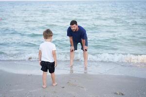 Father son spending time together sea vacation Young dad child little boy walking beach photo