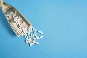 pills empty blisters for drugs individual syringe and money lie on a blue background photo