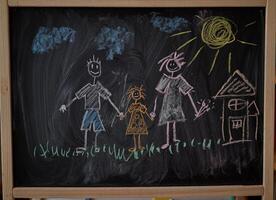 Children multicolored chalk drawing on blackboard photo