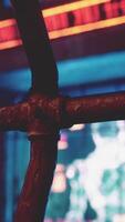 A close up of a metal fence with neon lights in the background video