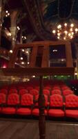 An empty theater with red seats and chandeliers video