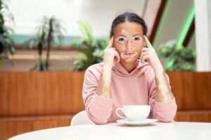 Black african american woman with vitiligo pigmentation skin problem indoor dressed pink hoodie photo