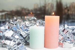 winter decor on windowsill with two candle and silver foil photo