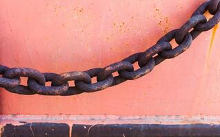 Part of an old rusted chain on a riverside photo