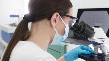 Medical Research Scientist Looks at Biological Samples Under Digital Microscope in Applied Science Laboratory. Beautiful Caucasian Lab Engineer in White Coat Working on Vaccine and Medicine video