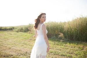 Beautiful caucasian girl walking on the field. Summer time day photo