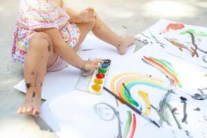 Portrait of little blonde girl painting, summer outdoor. photo
