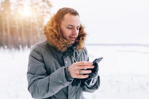 man wearing gray winter jacket with hood on in winter snow photo