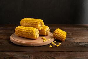 Corn cob with lies on cutting board wooden table background. photo