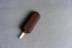 hielo crema palo en oscuro antecedentes cubierto chocolate palos congelado paleta de hielo y paleta dulce postre plano laico foto