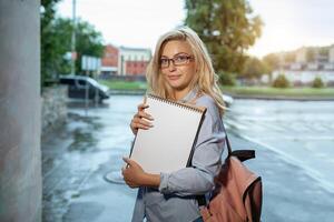 Enthusiastic Happy beautiful young girl smilin gand holding pile of books standing near campus lifestyle positivity academic graduating university school photo