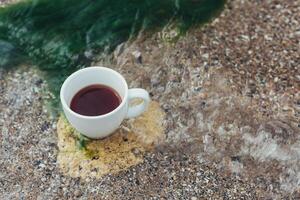 taza de café en el mar agua y Roca antecedentes. mar frescura Mañana concepto foto