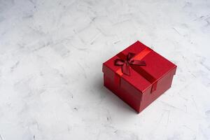 Red square holiday gift box against a white  background photo