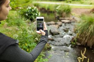 pecho, Francia 28 mayo 2018 mujer turista tomando foto con inteligente teléfono en el naturaleza