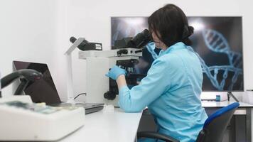 médico pesquisa cientista parece às biológico amostras debaixo digital microscópio dentro aplicado Ciência laboratório. lindo caucasiano laboratório engenheiro dentro branco casaco trabalhando em vacina e remédio video