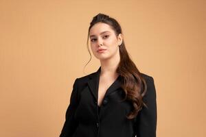 Young business woman close up portrait dressed black jacket standing studio isolated on color background. photo