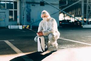 hombre vestido blanco protector mono pulverización superficie antibacteriano desinfectante rociador durante cuarentena foto