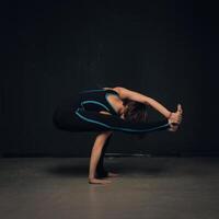 mujer practicando yoga en contra un oscuro texturizado pared foto