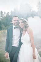 novia y novio a Boda día caminando al aire libre en verano naturaleza. nupcial pareja, contento recién casado mujer y hombre abrazando en verde parque. amoroso Boda Pareja exterior. novia y novio foto