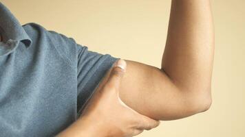 man flexing with arm raised against yellow background video