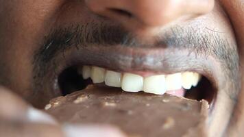 Closeup of men eating chocolate candy , video